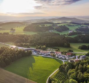 Wellnesshotel Reischlhof aus der Luft inmitten der grünen Landschaft des Bayerischen Waldes