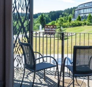 Balkon mit Sitzgruppe und Ausblick auf das Hotelgelände