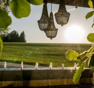 Eingangsbereich mit Brunnen und Hängelampen im Wellnesshotel Reischlhof