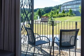 Balkon mit Sitzgruppe und Ausblick auf das Hotelgelände